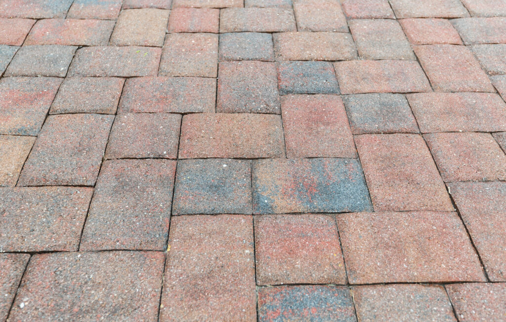 Faded pavers in need of sealing to restore their color and protect them.